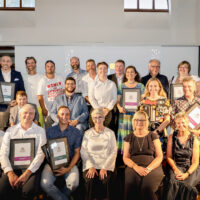 Finalists and winners of the Australian Access Awards pose on stage for a photo.