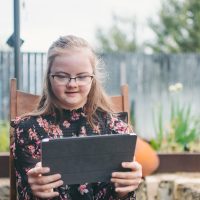 Banner image of girl looking at an iPad.