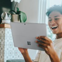 Person smiling using a Windows tablet device.