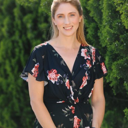 Photo: Dawn McAleenan, lady with long blond hair in a black dress with red and white flower print