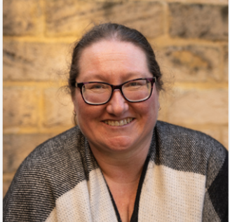 Photo of Colleen Hunter Woman wearing glasses with brown hair wearing a black white and grey wrap