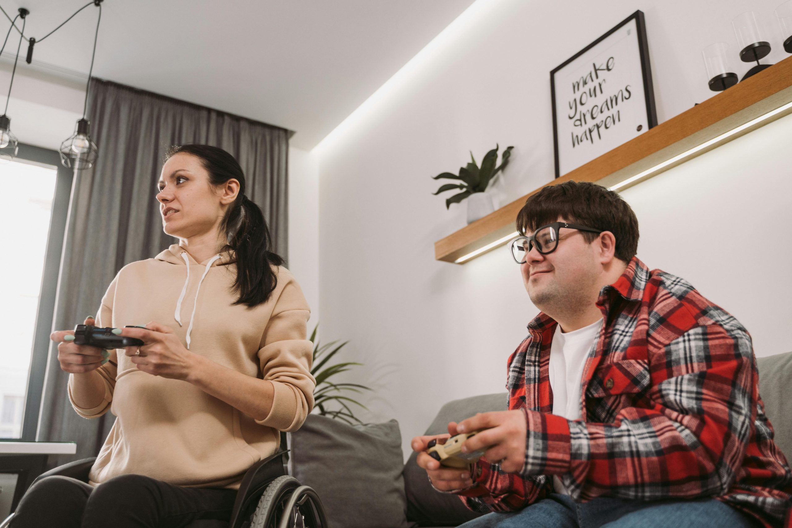 Two gamers, gaming, with consoles in their hands.