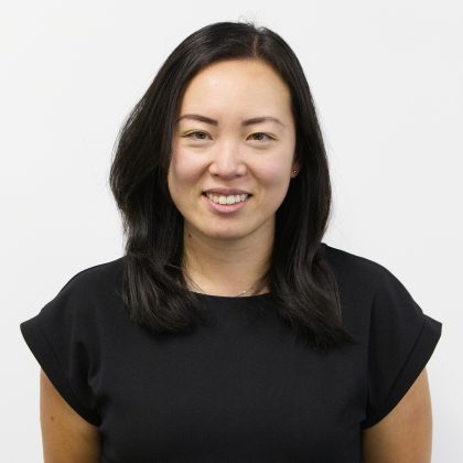 Yuemei Lim, wearing a stylish black top, smiles at the camera.