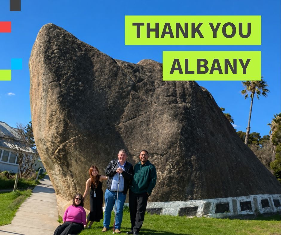 Four people standing in front of Dog Rock. Text says thank you Albany.